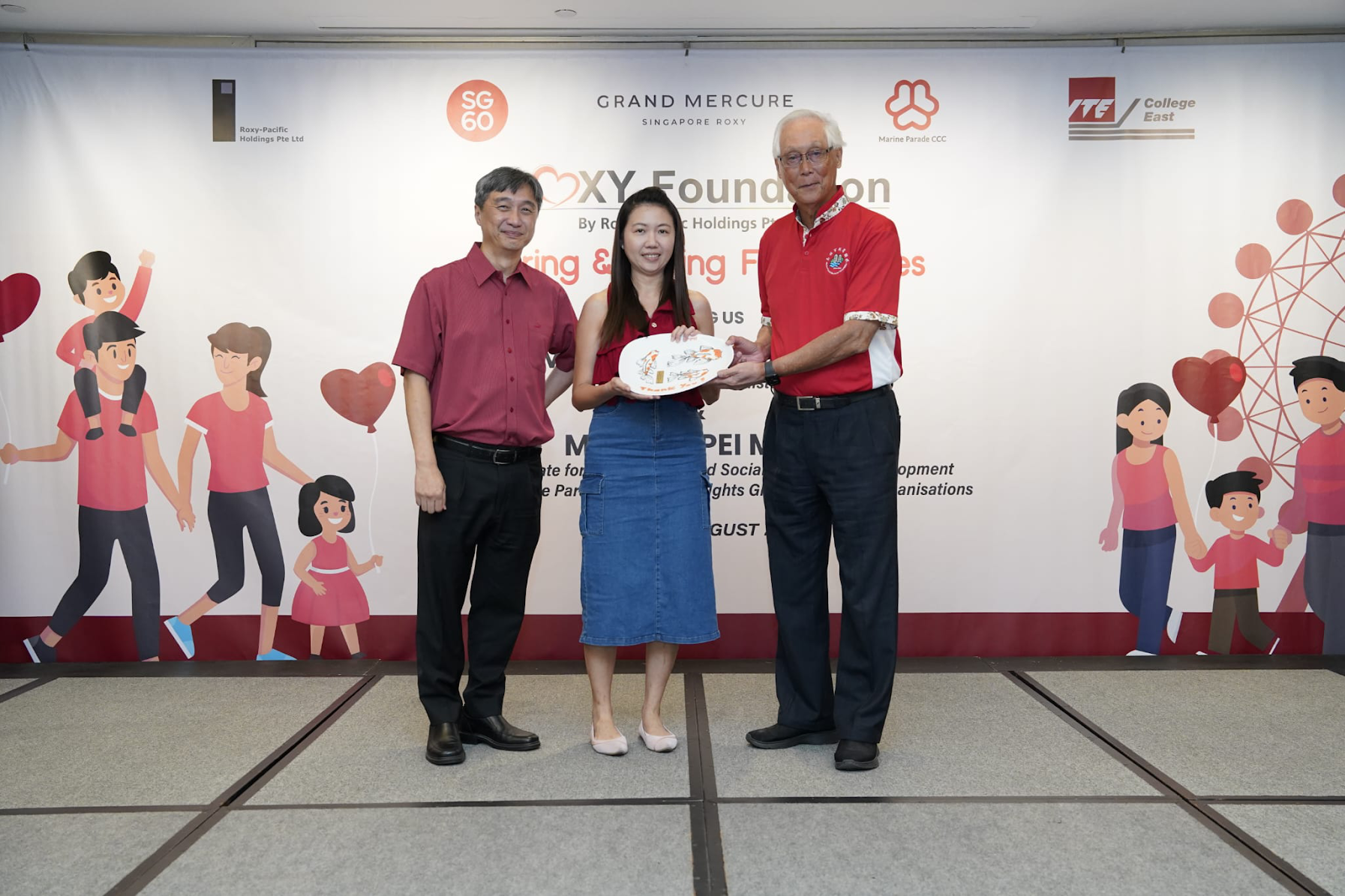 Angel receiving an acknowledgement from Emeritus Senior Minister Goh Chok Tong on behalf of Nanyang Inc.